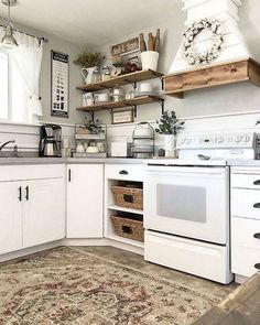 a kitchen with white cabinets and an area rug in front of the stove top oven