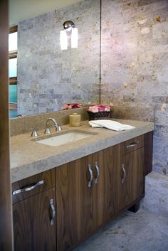 a bathroom with marble counter tops and wooden cabinets