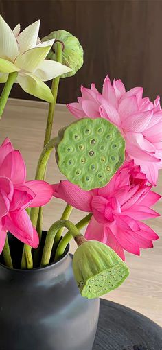 three pink and white flowers in a gray vase