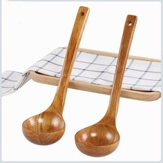 two wooden spoons sitting next to each other on top of a tablecloth covered tray