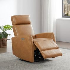 a recliner chair sitting on top of a rug in front of a window