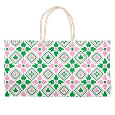 a large pink and green bag with flowers on it's front, sitting against a white background