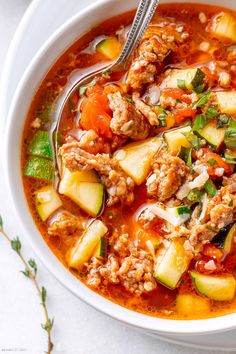 a white bowl filled with meat and vegetable soup