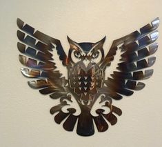 the metal owl is hanging on the wall