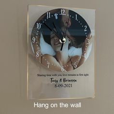 a glass clock with a couple kissing on the face and saying hang on the wall