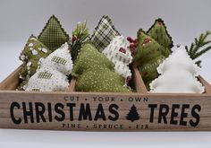 a wooden box filled with christmas trees on top of a table