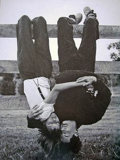 two people are upside down in the grass