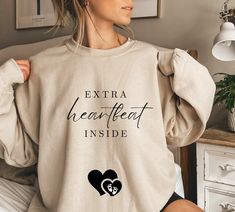 a woman wearing a sweatshirt that says extra heartbeat inside