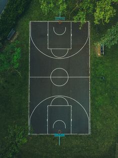 an overhead view of a basketball court in the middle of a field with trees around it