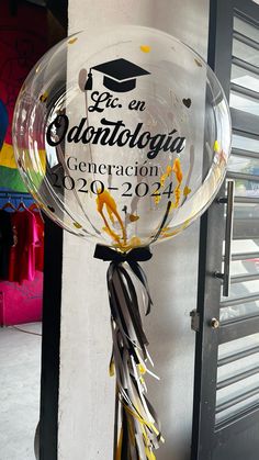 a graduation balloon hanging from the side of a building with confetti on it