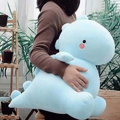 a woman holding a large blue teddy bear