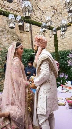 a man and woman standing next to each other in front of a table covered with flowers