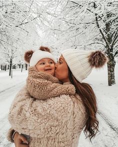 a woman holding a baby in the snow