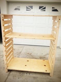 an unfinished shelving unit sitting in front of a garage door with no one inside