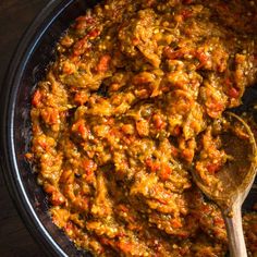 a wooden spoon in a bowl filled with food