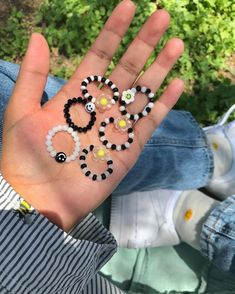 a person's hand with beads on it and the word love spelled in small letters