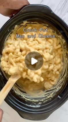 a person stirring macaroni and cheese in a crock pot