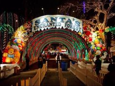 the entrance to santa's enchanted forest is lit up with christmas lights