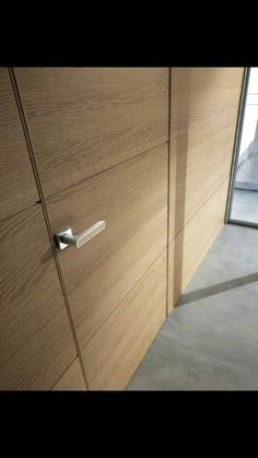 a close up of a door handle on a wooden cabinet