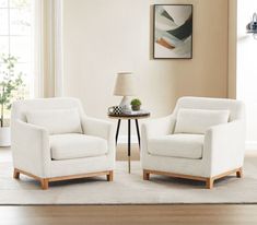 two white chairs sitting next to each other in a living room