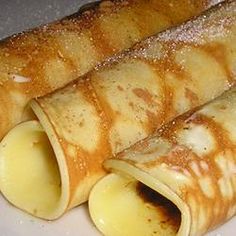 two crepes on a plate covered in powdered sugar and syrup are ready to be eaten