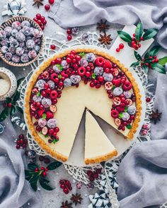 a pie topped with berries and cheese on top of a table