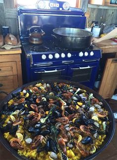 a large pan filled with lots of food on top of a counter next to a stove