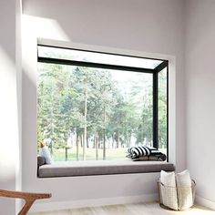 a window with a bench and pillows in front of it on the side of a wall