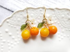 "glass orange drop earrings with cute white flower and green leaf Material: glass oranges, arcylic leaf and flower, gold plated hook drop length: about 1.25\" Contains small parts. Use caution when giving to young children less than Age 3 Please keep them away from moisture. If you have any questions, please feel free to contact me. Thanks :)" Purple Dangle Earrings, Earrings Food, Peach Earrings, Pear Earrings, Fruit Jewelry, Food Earrings, Fruit Earrings, Orange Earrings, Pretty Earrings