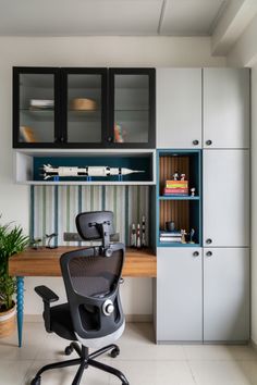 an office chair sitting in front of a desk with cabinets on the wall behind it