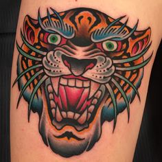 a colorful tiger tattoo on the thigh