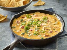 a skillet filled with tortilla soup and chips on the table next to it