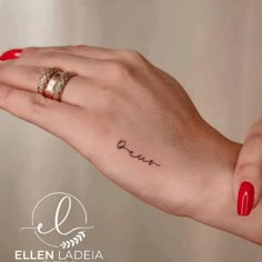 a woman's hand with a small tattoo on her left wrist and the word love written in cursive font