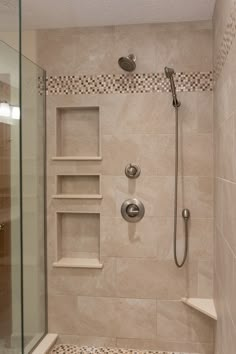 a walk in shower sitting next to a tiled wall