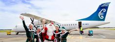 some people dressed as santa clause standing in front of an airplane on the tarmac