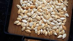 pumpkin seeds on a wooden cutting board ready to be cooked and put in the oven