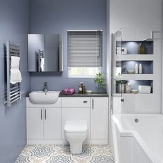 a bathroom with blue walls and white fixtures, including a sink, toilet, bathtub and shower