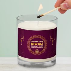 a person lighting a candle with a match stick in front of it that reads burning you a diwali moreli than