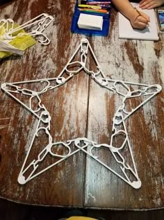 a wooden table topped with a star cut out of paper and colored crayons