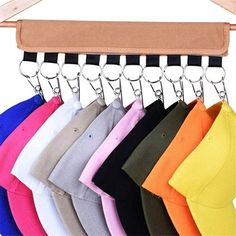 a rack with hats hanging from it's side and several colors on the hanger