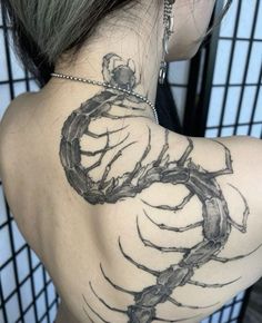 the back of a woman's shoulder with a scorpion tattoo on it