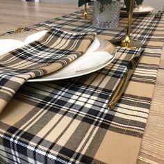 the table is set with black and white plaid napkins, gold place settings, and silverware