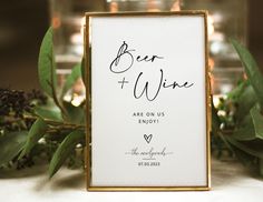 a sign that says beer and wine are on display next to some greenery with candles in the background