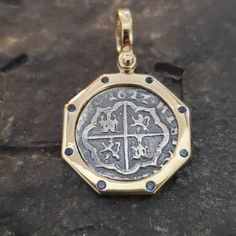 "A very beautiful piece, I use a porthole style bezel for this coin. The coin itself is casted from the silver bars recovered from the Atocha and comes with a certificate stating that. The frame is genuine solid 14kt gold.  The frame is also set with 8 genuine sapphire gemstones. This is also one of the few coins that have the date \"1622\" on it. The year the Atocha sank. A great and affordable piece of history. The size is about a dime,  and I sign my name on the back so you know you are getting a JackSpirit original design." Sunken Treasure, Treasure Coin, Key West Fl, Shipwreck, Silver Bars, Sapphire Gemstone, Key West, 14kt Gold, Real Gold