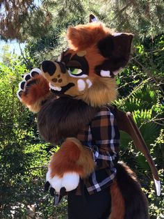 a stuffed animal is standing in front of some trees