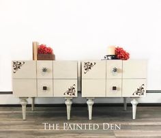 two white dressers with red pom poms on top and the words painted den above them