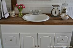 a bathroom with a sink, mirror and towel rack on the counter top in front of it