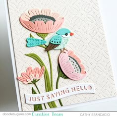 a close up of a card with flowers and a bird on the top of it