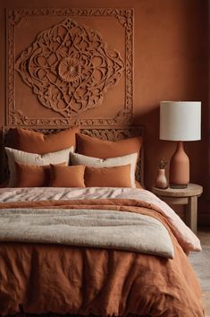 a bed with an orange comforter and pillows