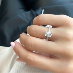 a woman's hand with a diamond ring on it